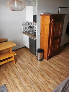 una pequeña cocina con suelo de madera y mesa en Studio rénové Chamrousse, au pied des pistes., en Chamrousse