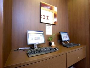 een bureau met twee computers erop bij Hotel Route Inn Tagajo-Eki Higashi in Tagajo