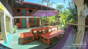 un patio con mesa, bancos y sombrilla en Blue Iguana, en Sámara