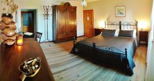 um quarto com uma cama grande e piso em madeira em Cà Gennara Agri B&B em Porretta Terme
