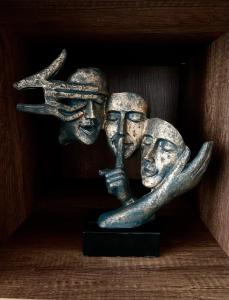 eine Statue mit zwei Händen, die drei Gesichter hochhält. in der Unterkunft Comfort Deluxe Flat in Ruse