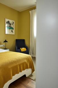 a bedroom with a yellow bed and a blue chair at Kuca Mira in Zaboric