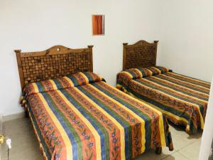 two beds sitting next to each other in a room at La Sirenita in Veracruz