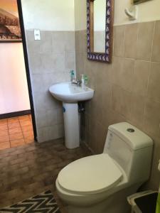 a bathroom with a toilet and a sink at Airport Rio Segundo Studio in Alajuela