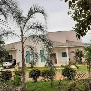 a house with a palm tree in front of it at Pousada Terra de Minas in Sacada