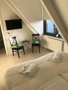 a bedroom with a bed and a tv and two chairs at Hart van Lochem in Lochem