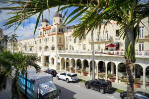 un gran edificio con coches estacionados frente a él en Palm Beach Historic Hotel with Juliette Balconies! Valet parking included! en Palm Beach