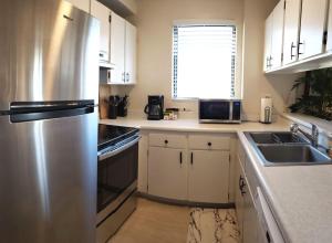 a kitchen with a stainless steel refrigerator and a sink at Waikiki Kuhio 1-bedrm Apt, Ocean view, Free Parking & Wifi in Honolulu