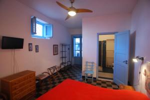 1 dormitorio con 1 cama y ventilador de techo en Vulcanoconsult Appartamenti Spiaggia, en Lipari