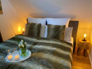 a bedroom with a bed with a tray of flowers and candles at Pension Haus am Wald in Braunlage