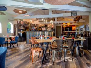 - un restaurant avec des tables et des chaises dans une salle dans l'établissement Logis Hotel Restaurant Uzès Pont du Gard, à Uzès