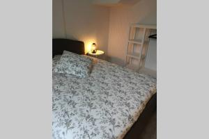 a bed in a small room with a lamp on a table at Au cœur de la Sologne in Romorantin