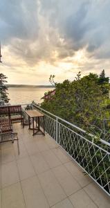 balkon z ławkami i widokiem na wodę w obiekcie Apartment Buco w mieście Starigrad-Paklenica