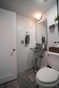 a bathroom with a white toilet and a sink at Palm Beach Historic Hotel with Juliette Balconies! Valet parking included! in Palm Beach