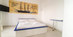 a bed in a room with a painting of a ship at Apartment Buco in Starigrad