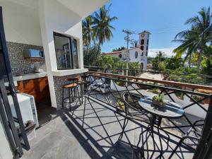 a balcony with a table and chairs and a clock tower at HOTEL OLAS ALTAS BUCERIAS in Bucer&iacute;as