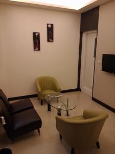 a waiting room with chairs and a table and a tv at Tilon Hotel in Pingtung City