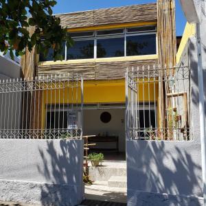 ein gelbes und weißes Gebäude mit einem Zaun in der Unterkunft Pousada Maraki in Maceió