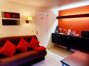 sala de estar con sofá marrón y almohadas rojas en Hebergement confort Comfortlogies La Fontanella, en La-Roche-en-Ardenne