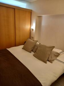 una camera da letto con un grande letto con cuscini di Hebergement confort Comfortlogies La Fontanella a La-Roche-en-Ardenne