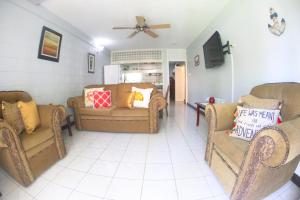 a living room with two couches and a ceiling fan at Fisherman Point Beach Resort in Ocho Rios