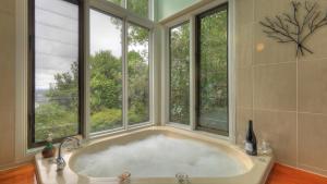 a bath tub sitting next to a window in a bathroom at Montville Misty View Cottages in Montville