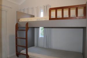 1 dormitorio con 2 literas y escalera en Praia de Quatro Ilhas a 50 metros do mar, en Bombinhas