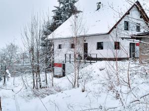 a white house with snow on the roof at Do zahrady in Liberec