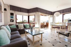 ein Wohnzimmer mit einem Sofa und einem Tisch in der Unterkunft Apartamento Lubina del Sol. 1ª linea de playa - By the Sea in Mijas Costa