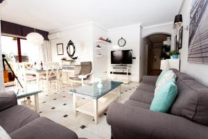 ein Wohnzimmer mit einem Sofa und einem Tisch in der Unterkunft Apartamento Lubina del Sol. 1ª linea de playa - By the Sea in Mijas Costa