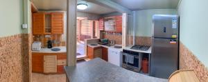 a kitchen with wooden cabinets and a stainless steel refrigerator at Sárkánytanya-Hanul Dragonului in Sicasău