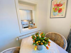 een eettafel met een vaas met bloemen erop bij Villa Caprivi - Ferienwohnung 7 in Heringsdorf