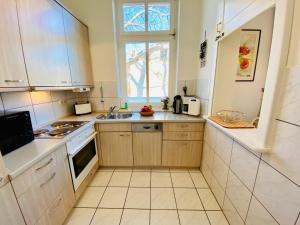 een kleine keuken met een wastafel en een raam bij Villa Caprivi - Ferienwohnung 7 in Heringsdorf