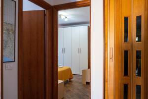 einen Flur mit Tür und ein Zimmer mit Bett in der Unterkunft Casa Rosy in San Vincenzo