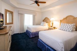 a hotel room with two beds and a ceiling fan at Bellasera Resort in Naples