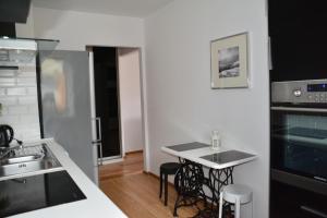 eine Küche mit einem Waschbecken und einem Tisch mit Stühlen in der Unterkunft Apartament Black & White Wczasowa in Ustka