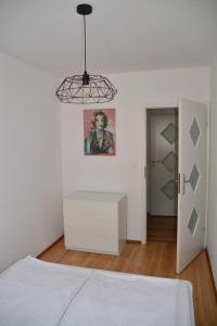 a bedroom with a white bed and a white dresser at Apartament Black & White Wczasowa in Ustka