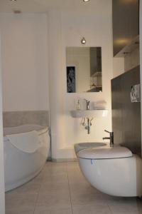 a bathroom with a tub and a toilet and a sink at Apartament Black & White Wczasowa in Ustka