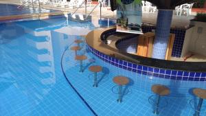 una piscina con taburetes en el agua en CALDAS NOVAS - FLAT PARQUE DAS ÁGUAS QUENTES - As piscinas mais quentes de Caldas!!, en Caldas Novas