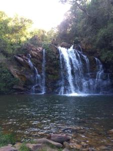 a waterfall in the middle of a body of water at Pousada do Canto in Rio Acima