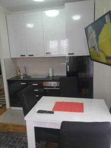 a kitchen with a white table with a tv on it at Apartment Adam-Zlatiborska Vila I in Zlatibor