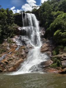 a waterfall in the middle of a river at Pousada do Canto in Rio Acima