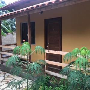 una casa con una valla y una puerta de madera en Pousada Bougainville en Três Corações