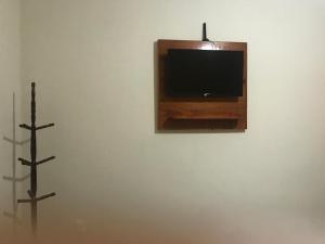 Un televisor en una pared con dos cruces. en Pousada Bougainville en Três Corações