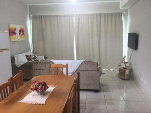 a living room with a table and a couch at Loft - Aeroporto in Florianópolis