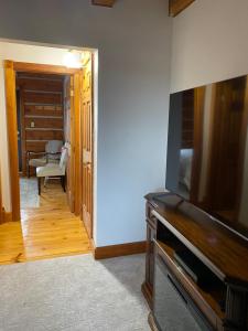 a living room with a flat screen tv and a hallway at Bye the Bay Bed and Breakfast in Ridgetown