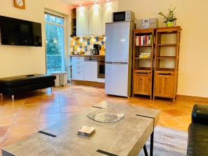 a living room with a table and a refrigerator at Residenz Bleichröder - Ferienwohnung 11 in Heringsdorf