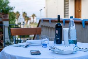 einen Tisch mit einer Flasche Wein und ein Handy in der Unterkunft Casa Rosy in San Vincenzo