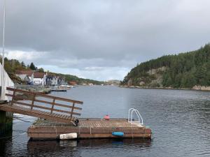 un muelle en un lago con una persona en él en 8 person holiday home in Urangsv g, en Steinsbø