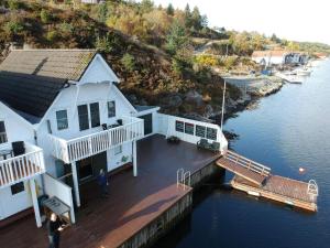 une maison blanche sur un quai dans l'eau dans l'établissement 8 person holiday home in Urangsv g, à Steinsbø